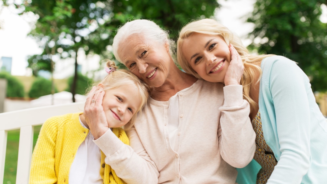 family, generation and people concept - happy smiling woman with daughter and senior mother sitting on park bench