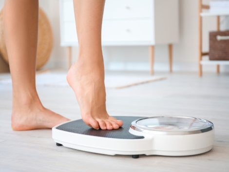 Young woman measuring her weight at home