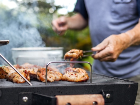 Senior man preparing barbecue grill for garden party. Selective