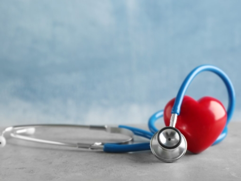 Stethoscope and red heart on table
